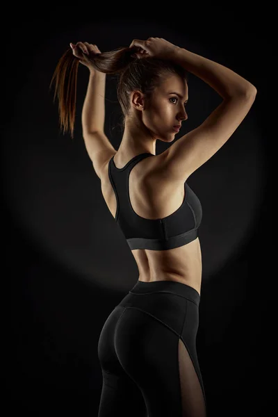 Stark sportig vacker kvinna i svarta sportkläder — Stockfoto