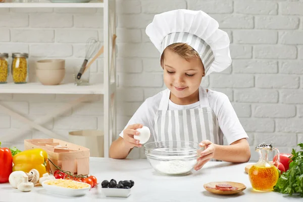 Kisgyerek fiú séf kalap és kötény főzés — Stock Fotó
