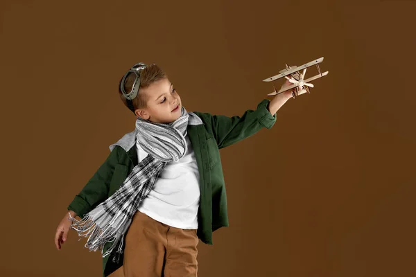 Glad pojke leker med trä leksak flygplan. dröm — Stockfoto