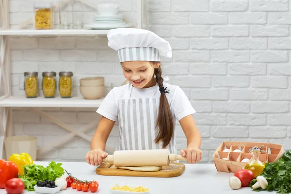 Kleines Mädchen rollt Teig aus — Stockfoto