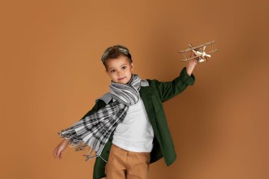 Mutlu çocuk tahta oyuncak uçakla oynuyor. rüya