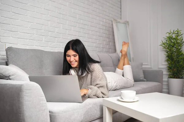 Vacker ung kvinna i hörlurar med bärbar dator — Stockfoto