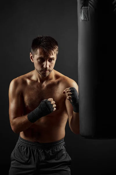 Boxeador masculino perforando en bolsa de boxeo — Foto de Stock