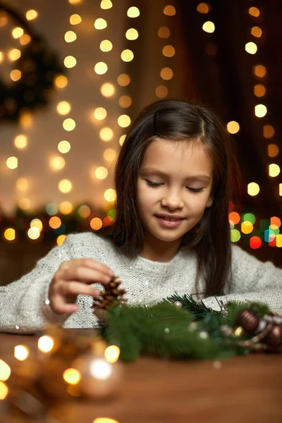 Happy cute little child girl makes a handmade Christmas wreath — Stock Photo, Image