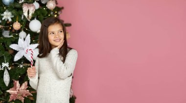 Küçük kız lolipop şeker kamışı tutuyor.