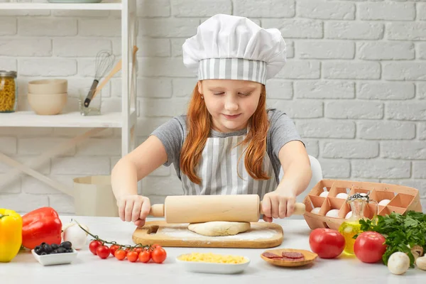 Kleines Mädchen rollt Teig aus — Stockfoto