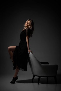 Stüdyo arka planında kıvırcık saçlı güzel sarışın kadın..