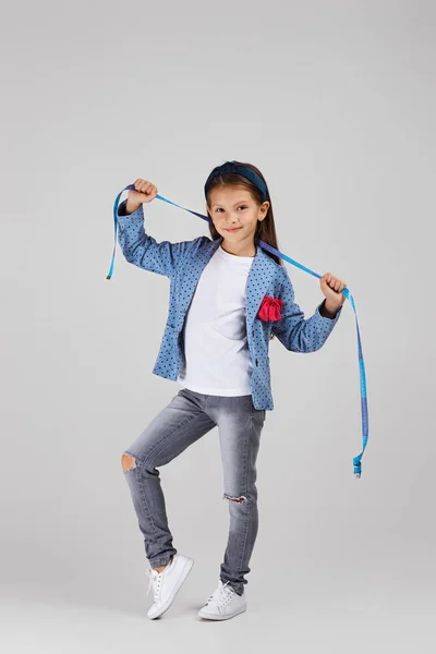 Щаслива маленька дівчинка тримає міру стрічки — стокове фото