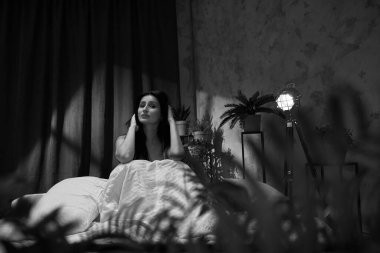 Güzel genç bir kadın yatak odasında uyuyor.