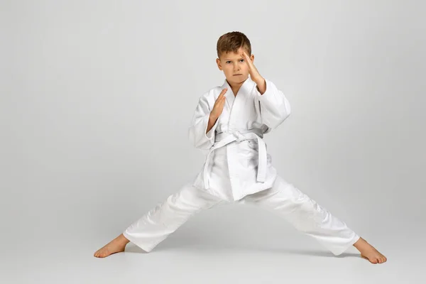 Мальчик, одетый в белое кимоно карате — стоковое фото