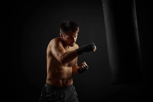 Мужской боксер бьет боксерскую сумку — стоковое фото