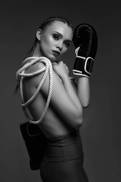 fashion sexy gorgeous woman model with black boxing gloves and white rope