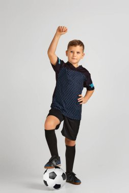 Top tutan üniformalı küçük futbolcu çocuk.