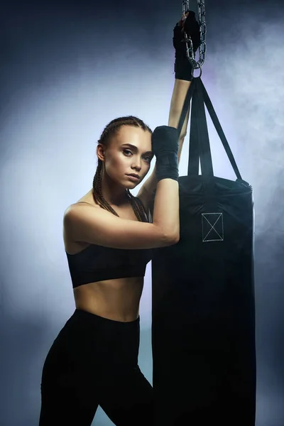 Αθλητική μελαχρινή γυναίκα με επιδέσμους πυγμαχίας κοντά τσάντα — Φωτογραφία Αρχείου