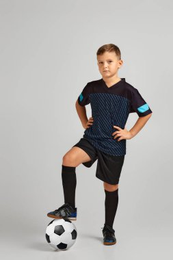 Top tutan üniformalı küçük futbolcu çocuk.