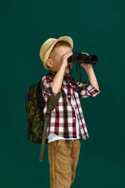 Liten pojke turist med ryggsäck tittar igenom en kikare. — Stockfoto