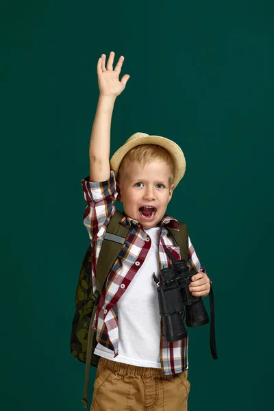 Liten pojke turist med ryggsäck innehav kikare. — Stockfoto