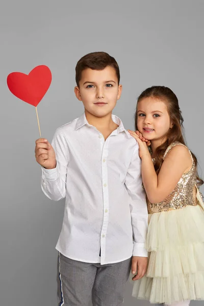 Счастливая пара маленькая девочка и мальчик с красными сердцами — стоковое фото