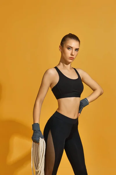 Mulher em sportswear preto com cordas pesadas — Fotografia de Stock