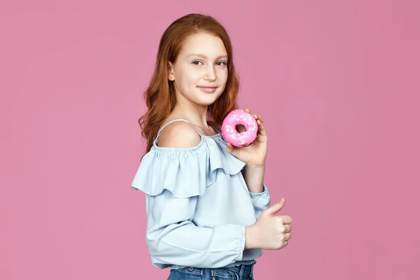 Linda niña atractiva sosteniendo rosquilla deliciosa —  Fotos de Stock