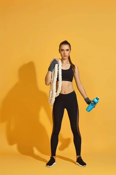 Mujer en ropa deportiva negra con cuerdas pesadas — Foto de Stock