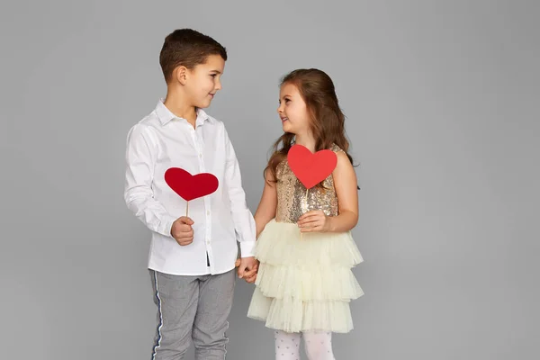 Lyckligt par liten flicka och pojke med röda hjärtan — Stockfoto