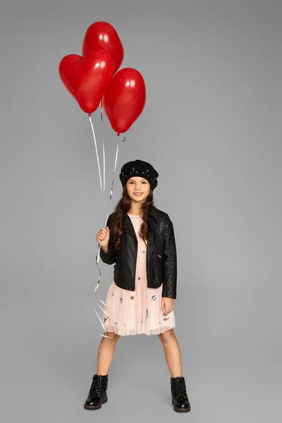 Щаслива дитина дівчина тримає червону кульку у формі серця — стокове фото