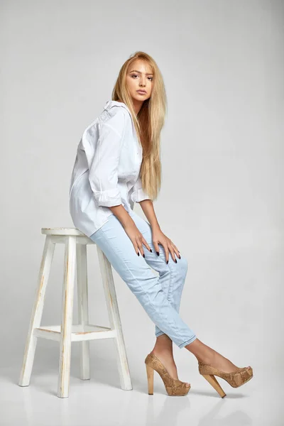 Mujer con el pelo largo en jeans y una camisa blanca — Foto de Stock