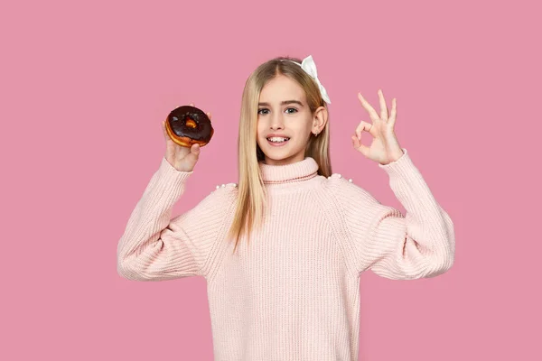 Cchild meisje holding lekker chocolade donut — Stockfoto