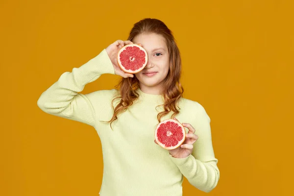 Мила маленька дівчинка тримає свіжий соковитий грейпфрут — стокове фото