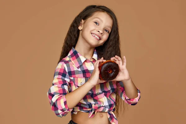 Niña sosteniendo delicioso donut de chocolate —  Fotos de Stock