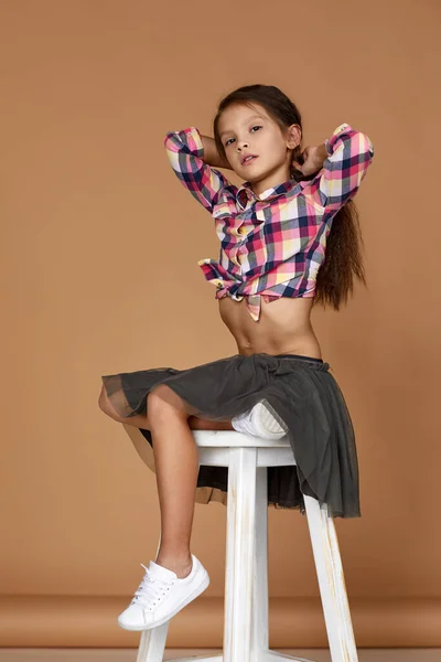 curly little child girl model in checkered shirt