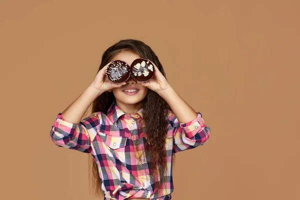 Dítě dívka drží dva dorty na tváři — Stock fotografie