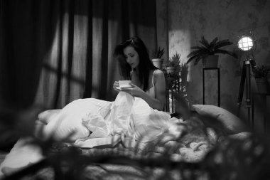 Güzel genç bayan kahvesini içiyor.