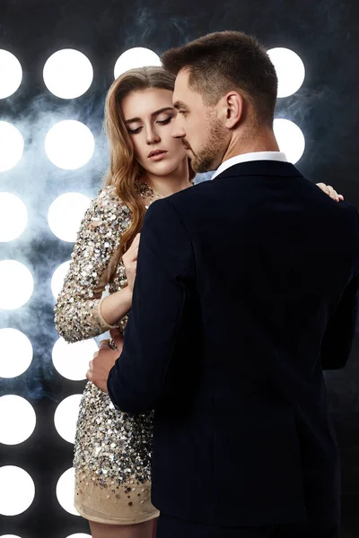 Par poserar mot bakgrund av spotlights — Stockfoto