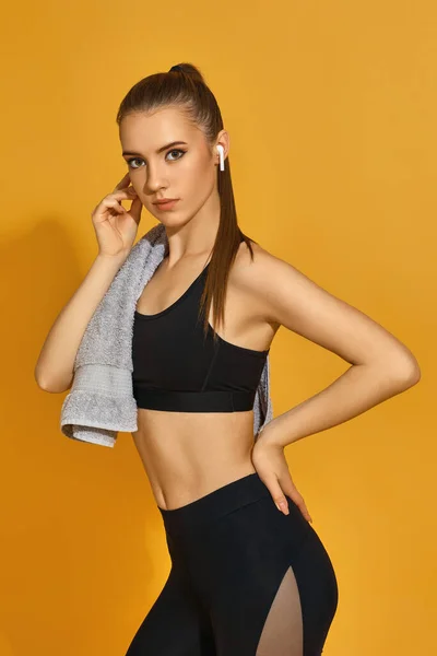 Ajuste jovem mulher em sportswear preto com toalha — Fotografia de Stock