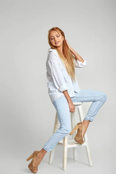 Mulher com cabelos longos em jeans e uma camisa branca — Fotografia de Stock