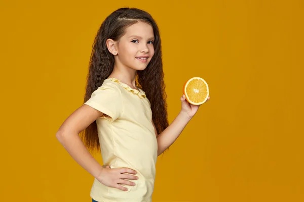 Niña sosteniendo naranja jugosa fresca — Foto de Stock