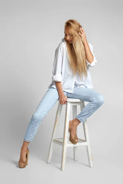 Mulher com cabelos longos em jeans e uma camisa branca — Fotografia de Stock