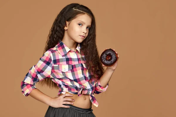 Дитяча дівчина тримає смачний шоколадний пончик — стокове фото