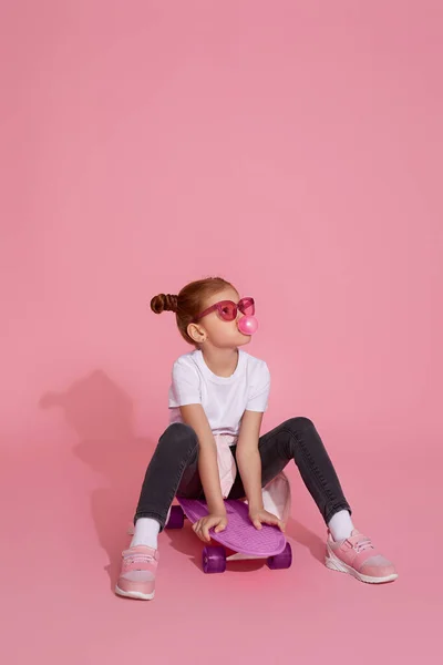 스케이트보드 위에 앉아 있는 귀엽고 작은 소녀 — 스톡 사진