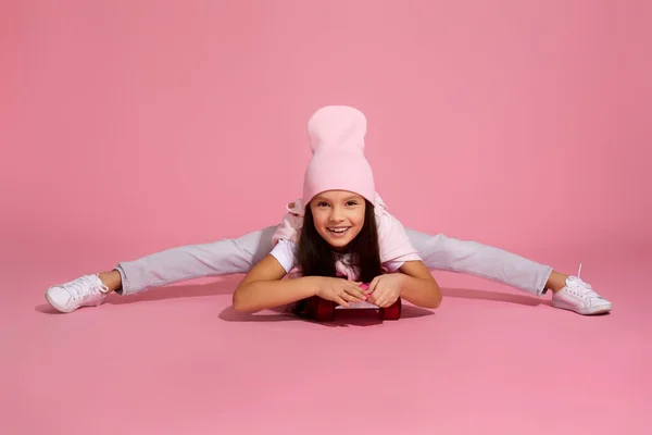 Niña riendo y sentada en patineta rosa — Foto de Stock