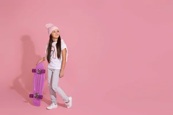 Adorável menina criança segurando skate rosa — Fotografia de Stock