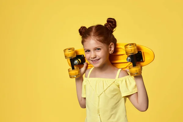 Niña con monopatín amarillo — Foto de Stock