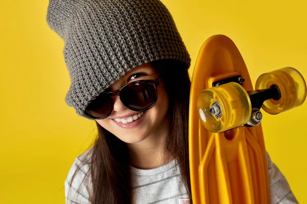 Kind meisje in hoed en zonnebril met geel skateboard — Stockfoto