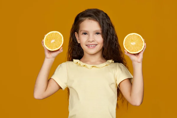Маленька дівчинка тримає свіжий соковитий апельсин — стокове фото