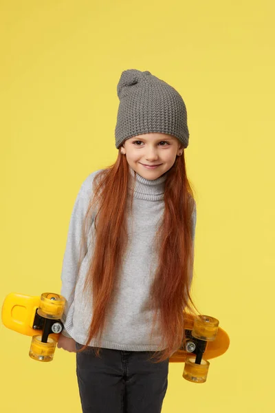 Kleines Mädchen mit gelbem Skateboard — Stockfoto