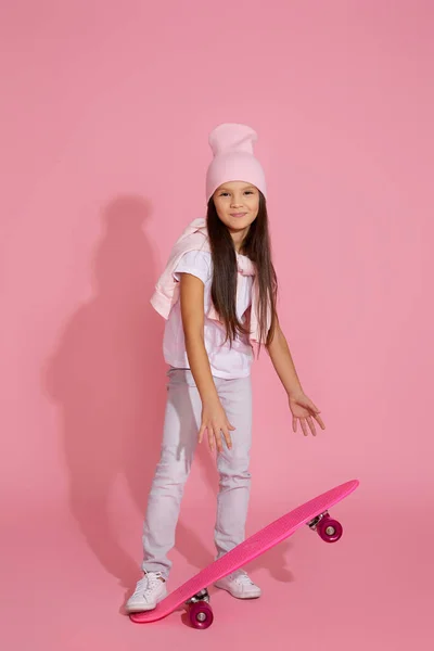 Чарівна маленька дівчинка з рожевим скейтбордом — стокове фото