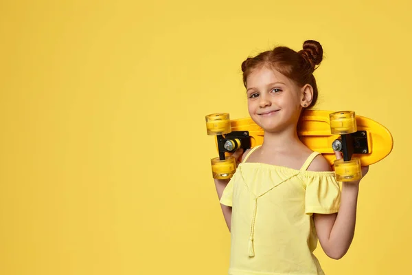 Menina criança com skate amarelo — Fotografia de Stock