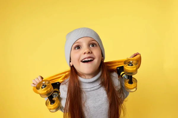 Liten barn flicka med gul skateboard — Stockfoto